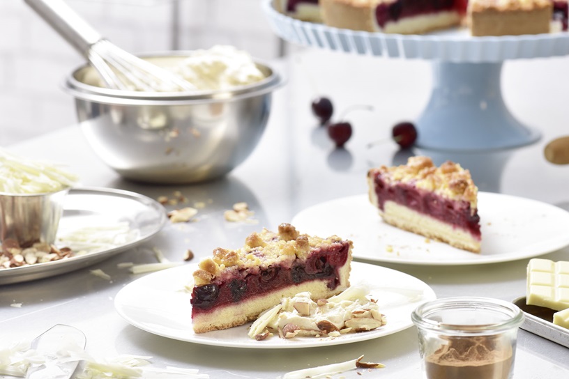 Kersentaart met boterkruimels met een crème van kaneel, witte chocolade en gezouten amandelen